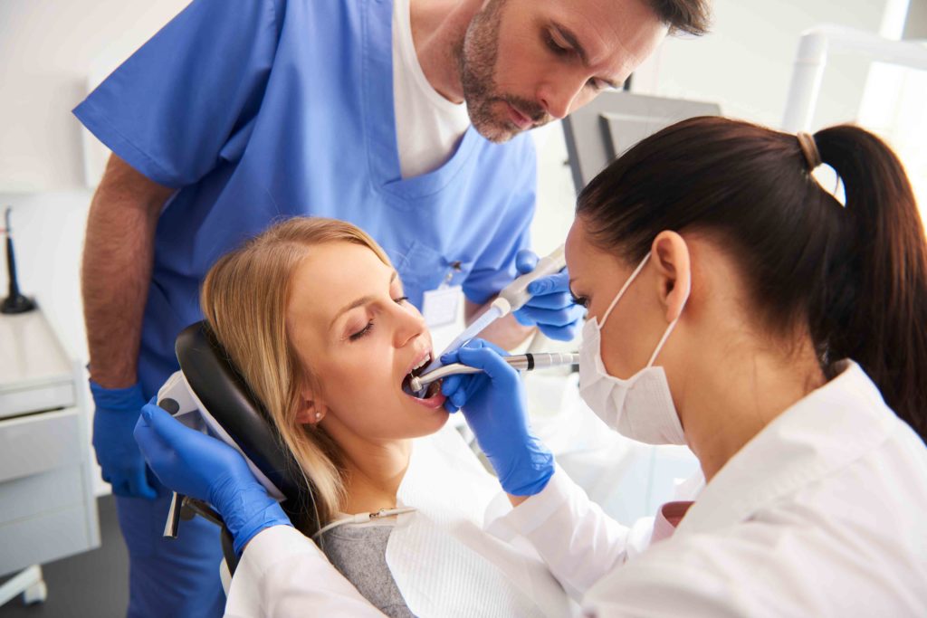 A dentist examining the mouth of a patient